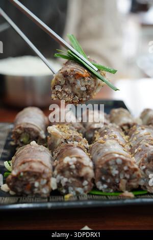Gros plan de Sundae de saucisse de sang coréenne tranchée garnie de graines de sésame et d'oignons verts Banque D'Images