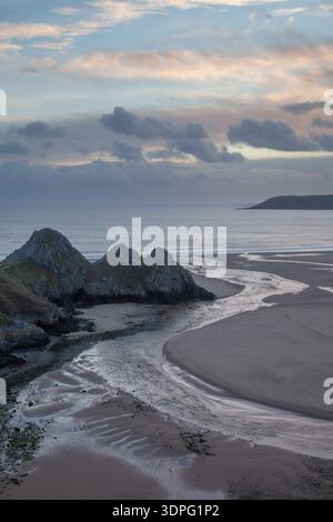 Vue côtière de style aérien sur un chenal de marée sinueux et une plage de sable avec des affleurements rocheux, une mer calme et une lumière douce sur la péninsule de Gower. Banque D'Images