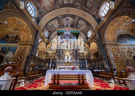 Valletta, Malta - 13 août 2025 : intérieur baroque de la Co-cathédrale John à la Valette, Malte, avec murs dorés, voûte en tonneau peint, autel supérieur, cha Banque D'Images