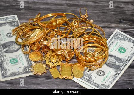 Le Caire, Egypte, 9 janvier 2026 : dollars américains USD argent et pile d'or sur une échelle numérique en grammes, lingots d'or, souverains, bracelets, bagues Banque D'Images