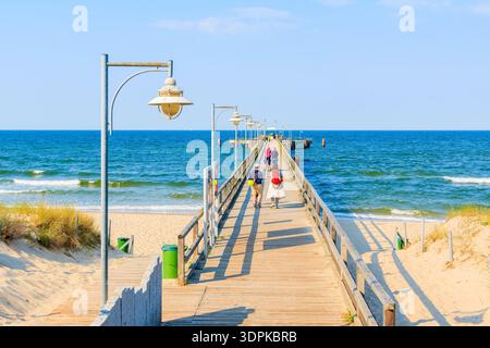 Touristes marchant sur la jetée dans la station balnéaire de Goehren avec belle plage, île de Ruegen, mer Baltique, Allemagne Banque D'Images