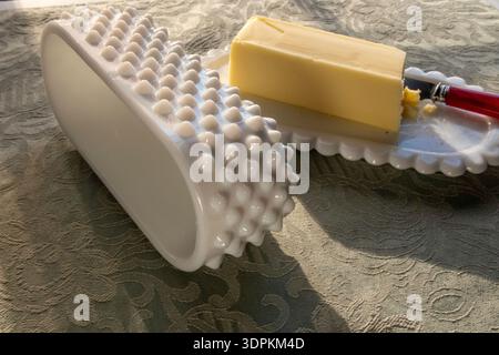 Nature morte d'un plat de beurre de hobnail en verre de lait antique sur une table de salle à manger, 2026, États-Unis Banque D'Images