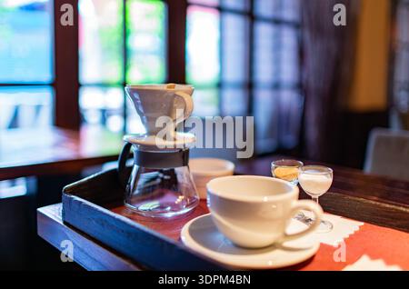 préparation artisanale du café avec carafe en verre et tasse en céramique blanche Banque D'Images