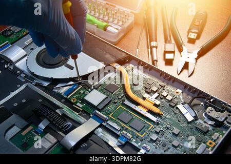 Vue latérale d'un technicien réparant un ordinateur portable. Banque D'Images