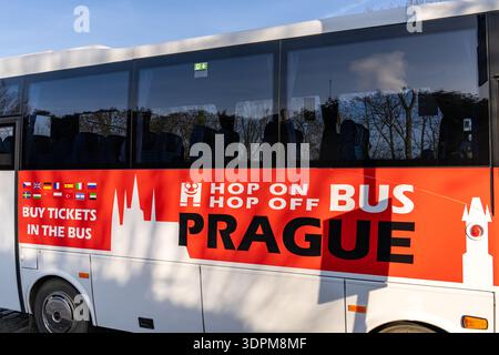 Prague, Tchéquie - 20 janvier 2025 : bus hop on Hop Off Prague avec le logo H souriant et divers drapeaux nationaux indiquant qu'un guide audio est disponible Banque D'Images