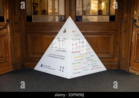 Prague, Tchéquie - 20 janvier 2025 : signe avec Bienvenue dans de nombreuses langues à l'entrée de l'église notre-Dame victorieuse où l'enfant Jésus du Pr Banque D'Images