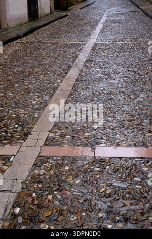 Rue pavée humide dans un village médiéval après la pluie, pavé traditionnel en pierre avec des surfaces réfléchissantes dans le quartier historique de Siguenza Banque D'Images