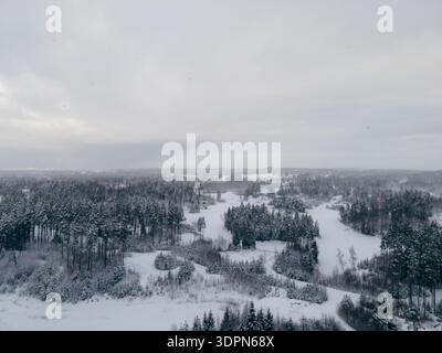 Vue aérienne de la forêt enneigée et rivière sinueuse dans le paysage d'hiver. Photographie par drone. Concept de nature et de nature sauvage d'hiver pour le design et l'impression. Vue aérienne Banque D'Images
