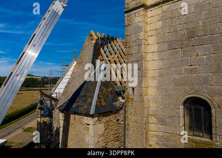 Eglise Saint Martin, France - 23 juillet 2020 : la structure apparente du toit en bois de l'église Eglise Saint Martin est visible aux côtés d'échafaudages, d'une grue de construction et de murs en pierre pendant les travaux de rénovation. Banque D'Images