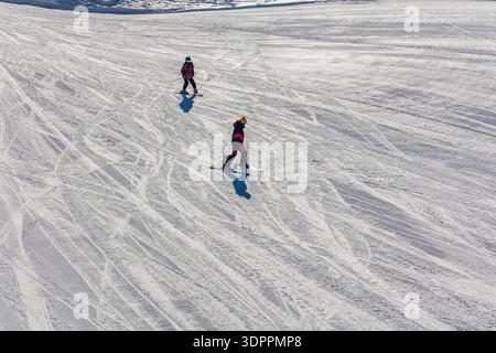 Vue en grand angle de deux skieurs sur une pente damée à la station de ski de Yokoteyama, Japon Banque D'Images