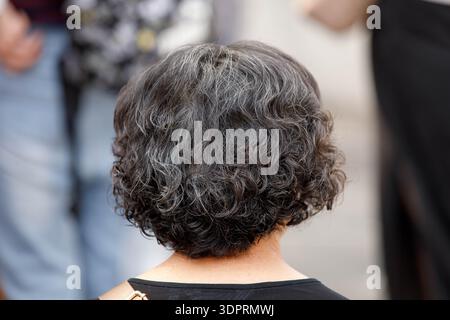 Touriste féminine avec les cheveux noirs et gris bouclés courts, la peau et la texture des cheveux, les cheveux gris, gros plan Banque D'Images