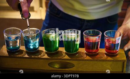Verres à café colorés avec cocktails superposés sur le comptoir du bar Banque D'Images