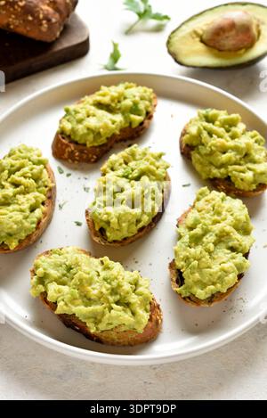 Toasts à l'avocat sur du pain de grains entiers. Concept d'alimentation saine. Arrière-plan clair, vue rapprochée Banque D'Images