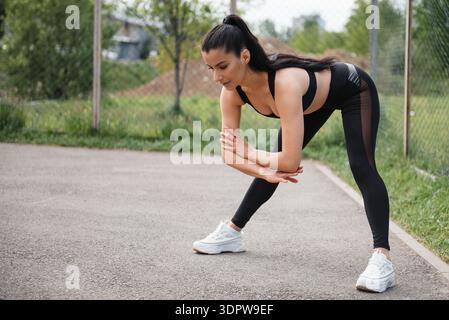 Fitness brune femme en leggings noirs d'entraînement en plein air Banque D'Images