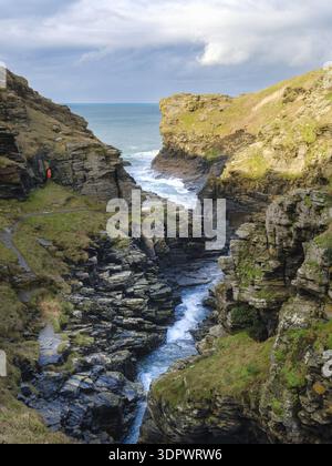 Vue sur les falaises escarpées embrasser la mer turquoise bouillonnante tandis qu'un étroit canal sculpte à travers le paysage rocheux, révélant la beauté brute de la côte Banque D'Images