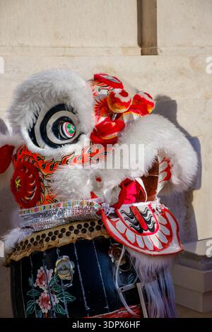 9 février 2024 - Lisbonne, Portugal : vue rapprochée de la tête du Lion Blanc, qui fait partie du spectacle traditionnel chinois de danse du lion reposant sur le drume traditionnel sur la place historique extérieure européenne après les célébrations du nouvel an lunaire. Apporte chance, fortune, prospérité Banque D'Images