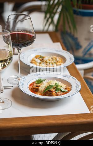 Lasagnes italiennes servies avec vin sur table Banque D'Images