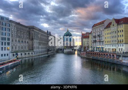 Berlin, Allemagne - 26 mars 2025 : vue sur la rivière Spree avec des bâtiments, des restaurants et la cathédrale de Berlin en arrière-plan Banque D'Images