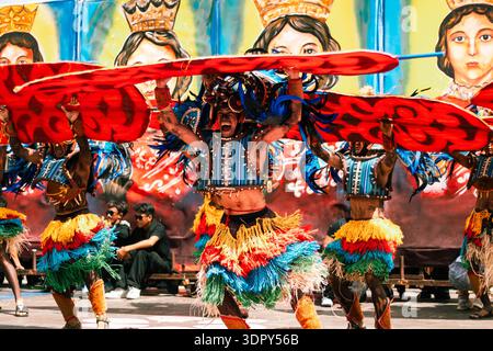 Iloilo City, Philippines - 25 janvier 2026 : vue de danseurs en costumes vibrants, leurs jupes à plumes un kaléidoscope de couleur sur fond de Banque D'Images