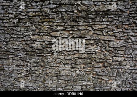Fond abstrait plein cadre d'un mur de bloc de calcaire naturel brun bronzé attrayant dans un motif ashlar, avec des blocs de pierre de texture robuste en plein soleil Banque D'Images
