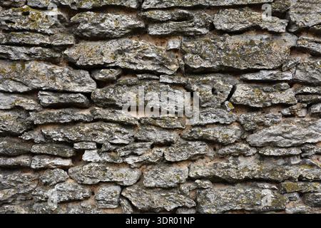 Fond abstrait plein cadre d'un mur de bloc de calcaire naturel brun bronzé attrayant dans un motif ashlar, avec des blocs de pierre de texture robuste en plein soleil Banque D'Images