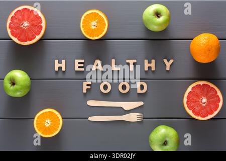 Affichage de fruits frais et de lettres en bois formant des aliments sains sur une table Banque D'Images