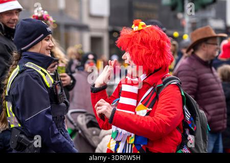 Rosenmontagszug in Düsseldorf, Einsatzkräfte, sichern, begleiten den Umzug, Polizistin mit geschenkten Blumen Sträußchen, Strüsschen, BEI teils starkem Regen, NRW, Deutschland Rosenmontag dus *** Rosenmontag parade in Düsseldorf, services d'urgence, sécuriser, accompagner la parade, policière avec bouquets de fleurs, bouquets, sous une pluie partiellement forte, NRW, Allemagne Rosenmontag dus Banque D'Images