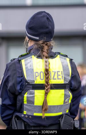 Rosenmontagszug in Düsseldorf, Einsatzkräfte, sichern, begleiten den Umzug, Polizistin mit geschenkten Blumen Sträußchen, Strüsschen, BEI teils starkem Regen, NRW, Deutschland Rosenmontag dus *** Rosenmontag parade in Düsseldorf, services d'urgence, sécuriser, accompagner la parade, policière avec bouquets de fleurs, bouquets, sous une pluie partiellement forte, NRW, Allemagne Rosenmontag dus Banque D'Images