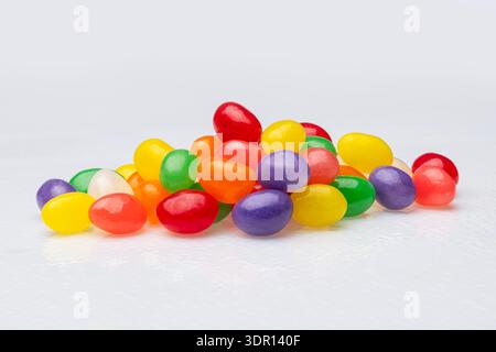 Gros plan d'une pile de Jellybeans aux couleurs vives sur un fond blanc Banque D'Images