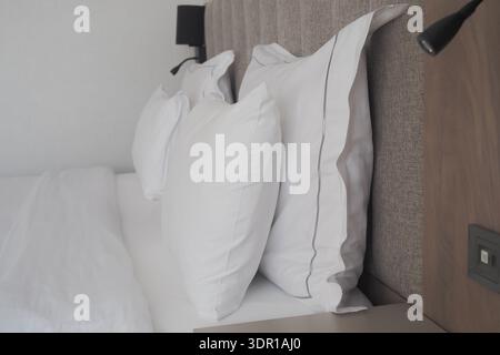 Lit confortable avec oreillers blancs dans une chambre d'hôtel Banque D'Images