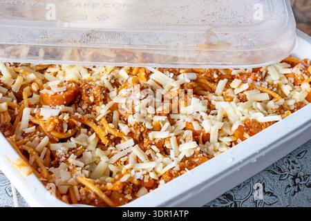 Spaghetti doux de style philippin avec fromage râpé dans un récipient en plastique Banque D'Images