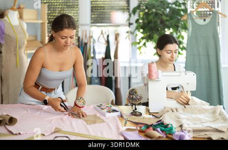 Deux tailleurs féminines créant des vêtements personnalisés en atelier Banque D'Images