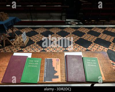 Hymnes et livres de prière sur un banc dans le chœur de la cathédrale chrétienne d'Ely, Angleterre. Banque D'Images