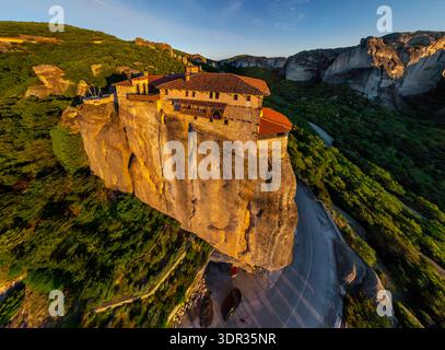 Vue aérienne du monastère de Roussanou perché au sommet d'un pilier rocheux imposant, baigné dans la lueur chaude du coucher de soleil, Kalabak, Trikala, Grèce. Banque D'Images