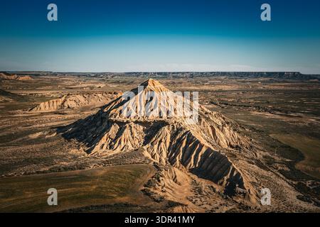 Vue sur un paysage spectaculaire et spectaculaire avec une montagne proéminente et clairement définie contre les vastes plaines arides sous un ciel bleu clair, Bardenas Rea Banque D'Images