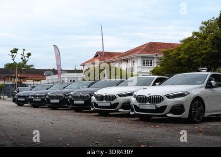 Rangée de voitures BMW neuves garées devant une concession à Georgetown, en Malaisie, avec différents modèles en finitions blanches et noires. Banque D'Images
