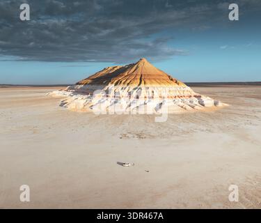 Vue aérienne de la majestueuse montagne de grès en couches s'élève du sol plat et aride du désert sous un ciel spectaculaire, Mangystau, région de Mangystau, Kaza Banque D'Images