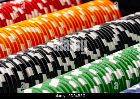 Piles colorées de jetons de poker arrangés pour une soirée de jeu dans un cadre de casino Banque D'Images