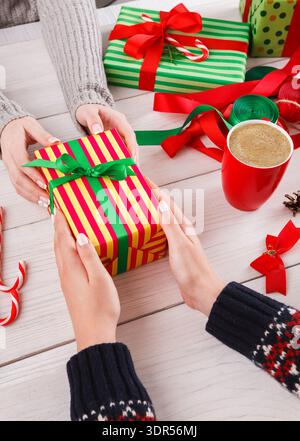 Échange de cadeaux pendant la période des fêtes avec décorations et boissons chaudes Banque D'Images