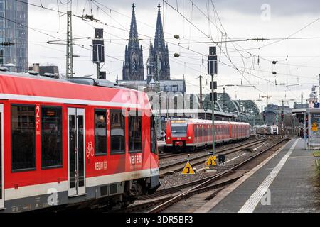 Trains locaux à la gare Messe-Deutz, en arrière-plan la cathédrale, Cologne, Allemagne. Nahverkehrszuege im Bahnhof Messe-Deutz, im Hintergrund der Do Banque D'Images