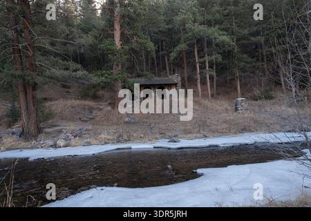 Lower Bear Creek coule à travers un paysage hivernal avec des taches de glace qui se forment le long des berges, tandis que l'eau libre continue en aval pendant la saison froide Banque D'Images