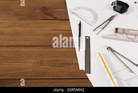 Divers outils de dessin et matériaux disposés sur une surface en bois avec montre et stylo Banque D'Images