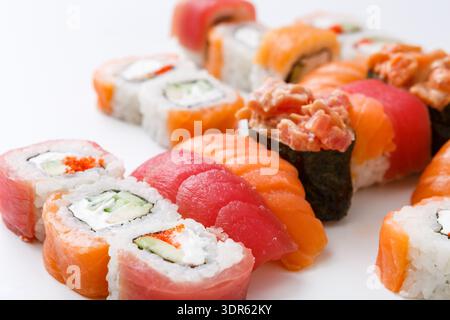 Différents types de sushis disposés soigneusement sur une surface blanche pour le plaisir de dîner Banque D'Images