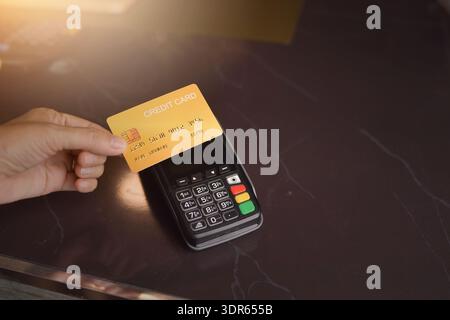 Vue rapprochée d'une personne payant avec une carte de crédit en utilisant un terminal de carte de crédit Banque D'Images