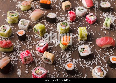 Sushi mis sur une table en bois avec différents types de sushi disposés dans un affichage coloré Banque D'Images