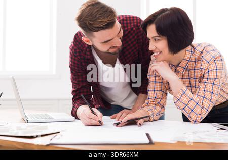 Deux personnes travaillant ensemble sur un projet dans un espace de travail lumineux et ouvert pendant la journée Banque D'Images