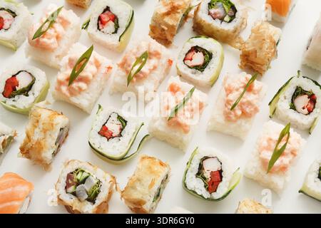 Différents types de Sushi disposés soigneusement sur une surface plane pendant une heure de repas Banque D'Images