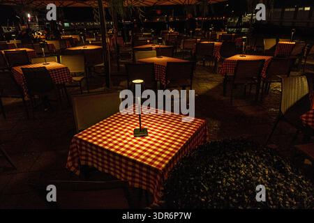Table de restaurant romantique éclairée aux chandelles avec tissu à carreaux rouge la nuit Banque D'Images