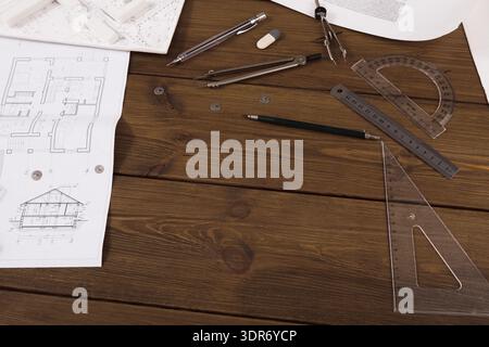Collection d'outils architecturaux et de documents sur une table en bois pour le travail de conception Banque D'Images