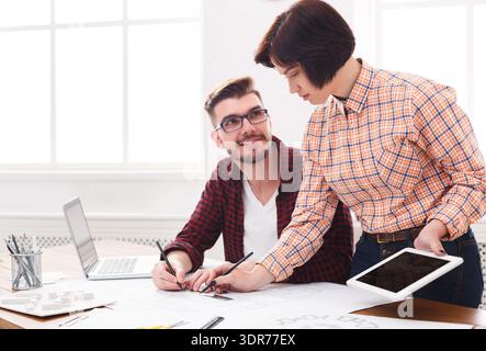 Collaboration entre deux personnes travaillant sur un projet dans un espace de bureau lumineux Banque D'Images